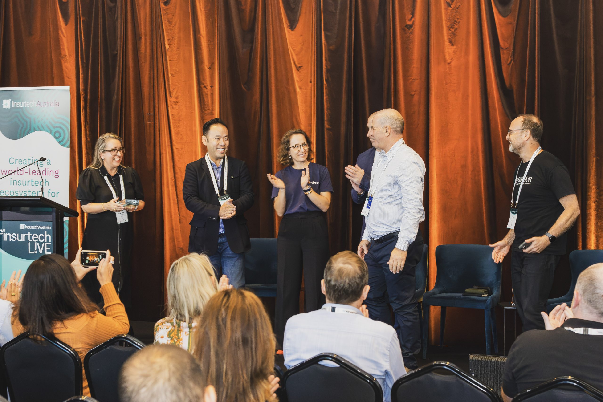 Participants on stage at an Insurtech Australia event